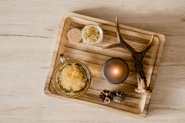 Aromatic candles and dried herbs arranged on a wooden tray