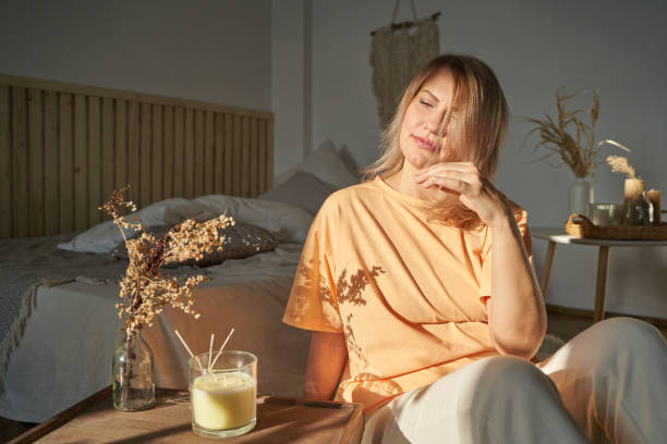 Person sitting peacefully near a softly lit scented candle